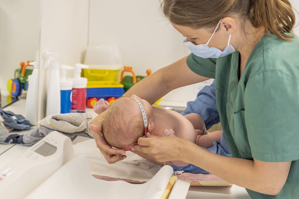 En helsesykepleier måler hodeomkretsen til en baby.