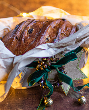 Til den som gleder seg til jul: Klassisk julebrød i beige silkepapir, grønt velurbånd og gullfarget julepynt. 