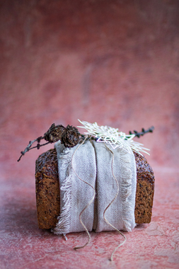 Til den gravide: Rugbrød med masse fiber og næring med et linhåndkle brettet som et bredt bånd på midten, med kvist, naturtråd og lekker julepynt.