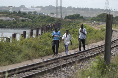 Unge menn gående langs togskinner                                