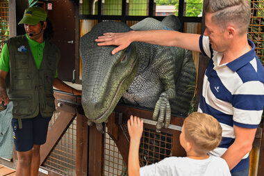 Far og sønn klapper dinosaur i Djurs Sommerland