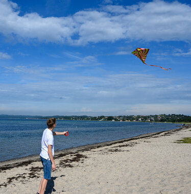 Gutt flyr drage på strand i Aarhus